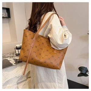 Detailed view of brown tote bag with monogram pattern and long shoulder straps