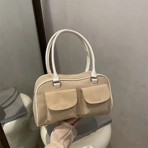 Vintage khaki suede tote bag with white piping and dual front pockets on round stand
