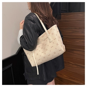 Detailed view of cream-colored tote bag with printed bunny patterns on a leather-like texture