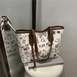 White graffiti printed tote bag with cartoon bears and slogans on a minimalist stand