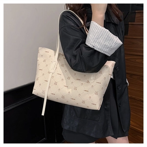 Close-up of cream tote bag featuring brown diamond patterns and animal motifs