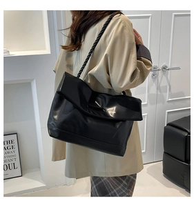 Close-up of soft black PU leather tote with unique braided rope shoulder strap detail
