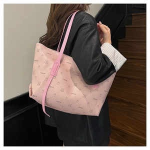 Detail of pink tote bag with rabbit pattern and textured lychee leather on model