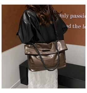 Detail of soft brown PU leather tote bag with unique woven rope handle and flap design