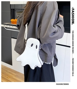 Lifestyle shot of a white cartoon ghost crossbody bag worn by a model in a cozy kitchen