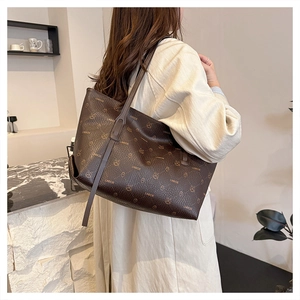 Model wearing a large vintage brown leather tote bag with stylish cartoon animal prints