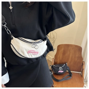 Detail view of crescent canvas chest bag with pink embroidery and double ring metal zippers