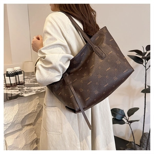 Lifestyle shot showing the large capacity brown tote bag worn on a woman's shoulder