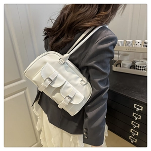 Close-up of a white glossy underarm bag featuring two front pockets and silver buckle straps