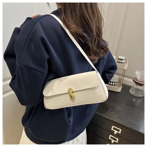 Close-up of white pebble leather bag with elegant gold hardware lock and shoulder strap