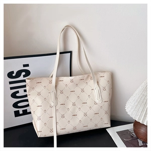Detailed macro view of cream tote bag featuring rabbit patterns and pebble grain texture