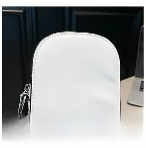 Close-up of fine stitching and silver hook detail on white leather crossbody bag