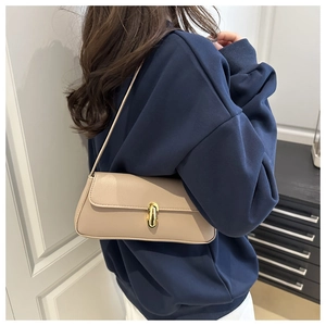 Detail der beige Baguette-Tasche aus strukturiertem Leder mit goldener Metallschließe