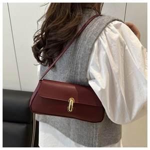 Detail der burgunderroten Leder-Baguette-Tasche mit edlem goldenem Drehverschluss