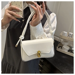 Detail of white leather bag featuring a gold unique lock and knotted shoulder strap