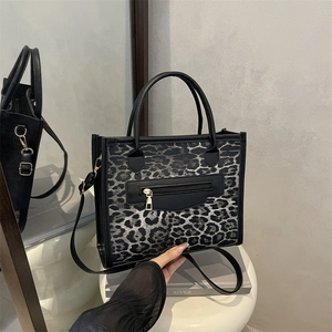 Fashionable leopard print crossbody tote bag with black handles and front zipper pocket