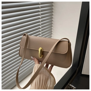 Close-up of khaki leather texture and gold twist lock on this minimalist shoulder bag