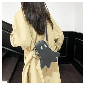 Ghost-shaped black crossbody bag shown from behind on a khaki trench coat