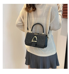 Detail of glitter patchwork crossbody bag with gold buckle on a fashion model