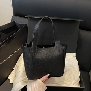 Large black lychee pattern leather bucket bag on white satin inside a gift box