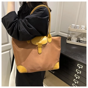 Détail du grand sac cabas en nylon avec finitions en cuir jaune et boucle de serrage