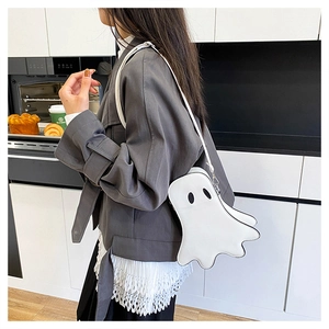 Ghost-shaped crossbody bag shown on model in a modern kitchen setting, white PU leather