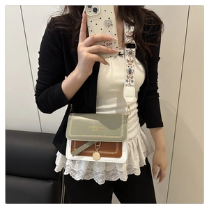 Detail view of tri-color crossbody bag with ethnic style embroidered wide strap