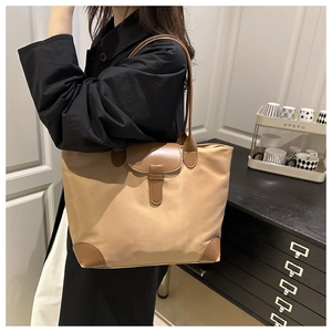 Detail of khaki oxford tote with brown leather handles and buckle closure for women
