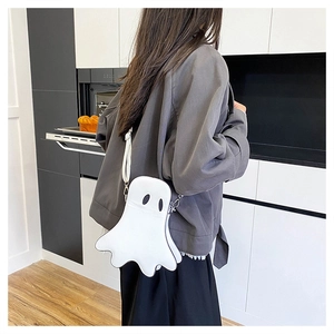 Detailed view of the white ghost-shaped crossbody bag worn by a model in a modern kitchen