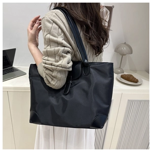 Détail du grand sac cabas noir en tissu Oxford avec renforts en cuir en scène de vie