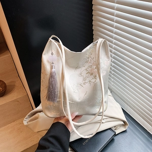 Sac fourre-tout brodé blanc cassé élégant avec motifs floraux et pompon en soie