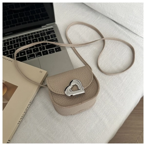 Détail d'un mini sac beige en cuir grainé avec un fermoir en métal argenté en cœur