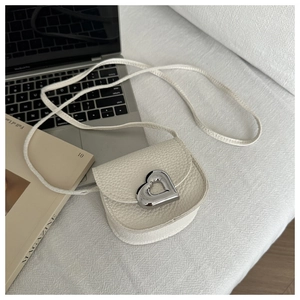 Détail du mini sac blanc cassé en cuir grainé avec boucle en métal cœur argenté