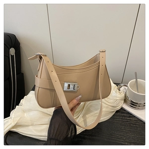 Détail du sac à bandoulière minimaliste beige avec fermoir rotatif carré en métal argenté
