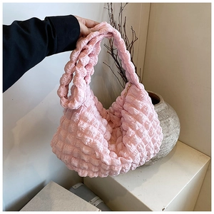 Close-up of pink puffy cloud bag with pleated texture and soft waffle fabric detail