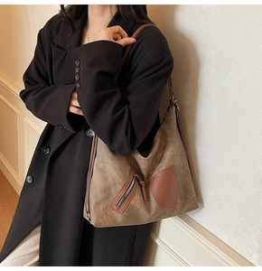 Detail of vintage brown textured tote bag featuring a leather strap and zipper design