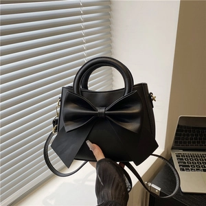 Elegant black tote bag with oversized bow detail and versatile detachable shoulder strap