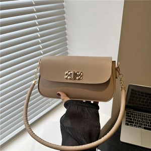 Minimalist beige crossbody bag with a golden woven lock and slim shoulder strap