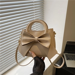 Chic beige leather handbag with large bow decoration and adjustable shoulder strap for women