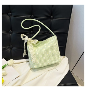 Detail of green plaid shoulder bag with daisy print and lace bow decoration
