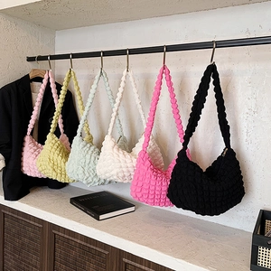 Multi-colored bubble texture shoulder bags in pink, yellow, green, and black displayed in a row