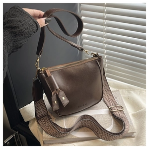 Detail van bruine retro tas met getextureerde stoffen band en gouden hardware