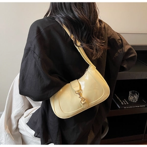 Détail du sac sous le bras en cuir glacé jaune clair avec boucle en métal vintage