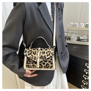 Detail of leopard print crossbody bag with beige PU leather and metal buckle closure