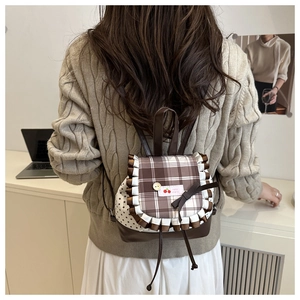 Détail d'un mini sac à dos en toile avec rabat à carreaux, dentelle et motifs étoiles