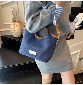 Blaue Denim-Beuteltasche mit braunem Kunstlederbesatz und verstellbarem Schultergurt