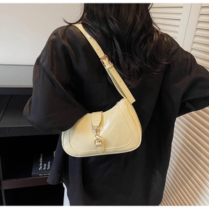 Détail du sac hobo en cuir brillant jaune clair avec boucle argentée et bandoulière réglable