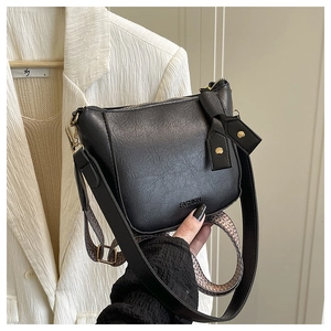 Nahaufnahme der schwarzen Retro-Tasche mit FASHION-Prägung und Jacquard-Gurtband