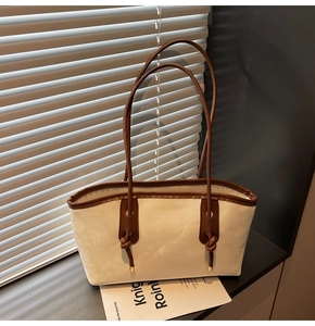 Detail of a beige tote bag with brown leather trim and Fashion & Bags text on surface