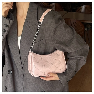 Rosa Baguette-Tasche mit Bärendruck und Kettenriemen am Modell im Blazer gezeigt